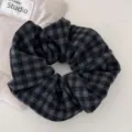 Vista detallada de coletero grande a cuadros grises tipo houndstooth con textura de tela suave - Coletero a Cuadros Gris Oscuro