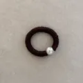 Close-up detail of a dark brown silk hair scrunchie with a large silver metallic bead. - Red Brown