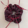 Detailed view of a vintage red plaid scrunchie featuring elegant red ribbon bows. - Red Plaid Bow Scrunchie