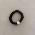 Close-up of black silk-like scrunchie with single white pearl bead detail - Dark Brown