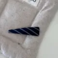 Primo piano di un fermaglio per capelli a triangolo in tessuto a righe blu su sfondo beige - Fermaglio per Capelli a Triangolo Piccolo / Saia Blu