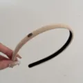 Detailed view of a minimalist beige suede narrow headband featuring a small 'Love' metal tag - Khaki
