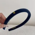 Detailed close-up of a navy blue velvet headband featuring a small gold bow charm - Dark Blue
