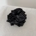Gedetailleerd overzicht van een donkere vintage geruite stoffen scrunchie met handlabel. - Zwarte Ruit Stijl / Zwarte Ruit