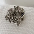 Detailopname van een retro geruite stoffen scrunchie met een echt handgemaakt label - Khaki Geruite Stijl / Khaki Geruit