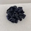 Vue rapprochée d'un chouchou en tissu à carreaux bleu marine et noir avec une étiquette faite main - Plaid Bleu Foncé