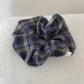 Detail view of retro plaid fabric scrunchie with handmade tag for elegant hair styles. - Blue Tone Plaid Scrunchie