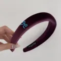 Close-up view of a premium purple velvet padded headband featuring a small blue bow - Wine Red Velvet Bow Headband