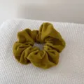 Close-up detail of retro mustard yellow velvet scrunchie showing soft fabric texture. - Yellow
