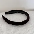 Close-up view of an elegant twisted velvet headband in dark brown with cross design - Coffee Velvet Headband