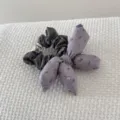 Detailed view of a vintage floral stuffed bow scrunchie on white textured fabric - Purple Bowknot Scrunchie (FJ83662)