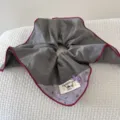 Detail view of a retro grey oversized scrunchie with burgundy piping and dog tag. - Gray Square Scarf (FJ83662)