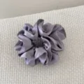 Détail d'un chouchou en satin violet de luxe à double couche avec des volants. - Gris