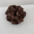 Vue détaillée d'un chouchou en satin marron foncé à double couche avec plis élégants - Marron