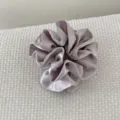 Détail d'un chouchou en satin gris à double couche avec plis et volants élégants - Mauve Clair
