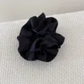 Détail d'un chouchou en satin noir à double épaisseur avec une texture de tissu élégante - Bleu foncé
