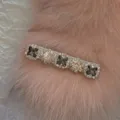 Close-up detail of sparkling rhinestone hair clip on soft pink faux fur background - Gray Rhinestone