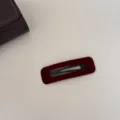 Vue détaillée d'une barrette BB en velours bordeaux au design géométrique épuré. - Carré / Rouge