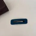 Gros plan détaillé d'une pince à cheveux BB en velours bleu montrant texture et couture - Carré / Bleu