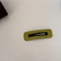 Vue détaillée de la texture en velours vert olive et des coutures de la pince à cheveux BB. - Carré / Vert