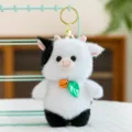 Cute black and white cow plush keychain with bell and leaf charm, soft cartoon purse tag. - Cow
