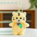 Cute plush tiger keychain yellow variant, soft stuffed animal bag charm with bell and leaf decor. - Tiger