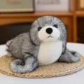 Peluche de león marino realista en color gris y blanco en posición tumbada - 27cm / Gris