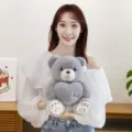 Cute grey sitting teddy bear plush toy with heart embroidery held by a female model - Gray / 28cm