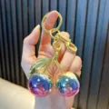Cute cherry fruit keychain with purple gradient spheres and gold-toned metal hardware. - Cherry / Glitter Blue