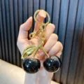 Cute resin cherry keychain featuring black glitter fruits and metallic gold leaves - Cherry / Black