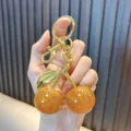 Cute resin sparkling orange fruit keychain with golden hardware and glitter finish - Cherry / Yellow