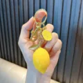 Detailed realistic yellow resin lemon fruit keychain pendant with shiny gold hardware - Lemon Yellow