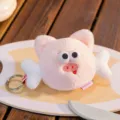 Macro view of a cute pink plush pig keychain with wings and silver metal ring charm. - Mini Pig Head