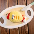 Adorable cute yellow plush chicken keychain charm displayed on a wooden serving board prop. - Chicken Leg