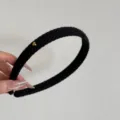 Primo piano di cerchietto in lana a coste nero con piccolo ciondolo a cuore dorato - Cerchietto con Cuore / Largo 1.5cm / Nero