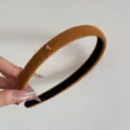 Primo piano di un cerchietto lavorato a maglia color caramello con cuore d'oro - Cerchietto con Cuore / Largo 1.5cm / Arancione