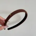 Dettaglio ravvicinato di un cerchietto in maglia marrone con strisce e cuore d'oro - Cerchietto con Cuore / Largo 1.5cm / Caffè