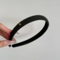 Primo piano di un cerchietto in maglia nera con cuore dorato e strisce diagonali - Cerchietto con Cuore / Largo 1.5cm / Verde scuro