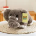 Peluche di elefante grigio con morbida pelliccia disteso su una stuoia di paglia - 30cm / Marrone
