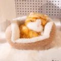 Adorable gato de peluche de simulación durmiendo en una cama para mascotas marrón - Gato Atigrado Dorado / 13cm