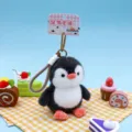 Cute black and white plush penguin keychain with hanging strap detail - Dressed Penguin