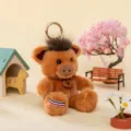 Adorable brown plush wild boar keychain with fluffy hair and decorative Happy tag - Porcupine