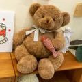 Ours en peluche marron doux avec nœud rayé tenant un poisson rouge à motifs - 35cm / Café