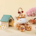 Cute spotted giraffe plush doll keychain ornament in a warm miniature scene setting - Giraffe