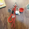 Sporty red baseball keychain featuring woven strap and mini bat glove charms accessory - Red