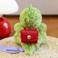 Adorabile dinosauro di peluche verde con un piccolo zaino rosso su un tappeto intrecciato - Stile Zaino Rosso / 15cm / Verde