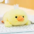 Adorable cute yellow fluffy duckling plush toy resting on a white computer keyboard - Yellow Duck