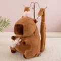 Adorable brown Capybara plush backpack with a pink bow and cute rabbit charm accessory. - Capybara Pink Bow Style