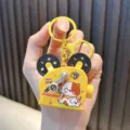 Yellow mini projector-shaped keychain with cute cat illustration and HELLO SPRING text. - Calico Cat Pattern / Yellow