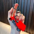 Red realistic miniature inertia tricycle toy keychain with functional pullback wheels - Red